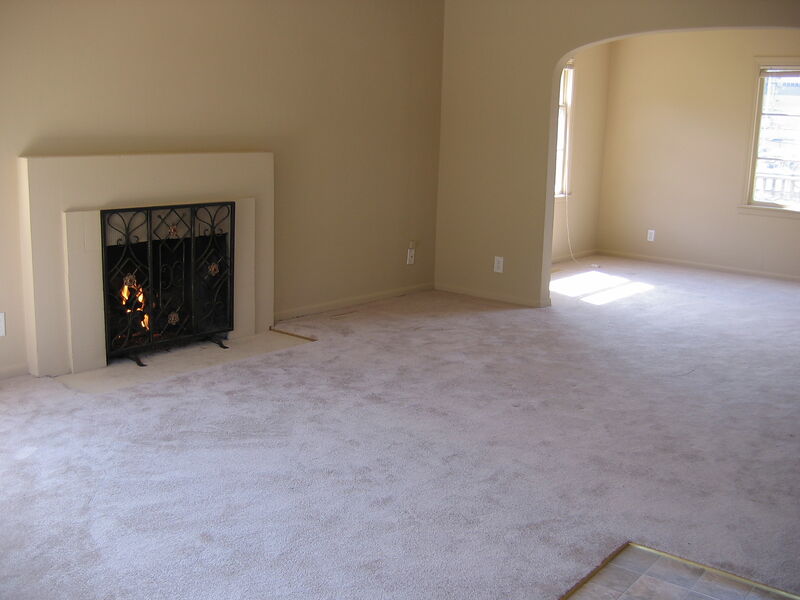 Living room with lit gas fireplace and Spanish archway