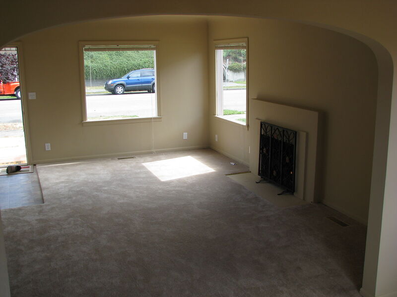 Living room from the dining room showing fireplace and front windows